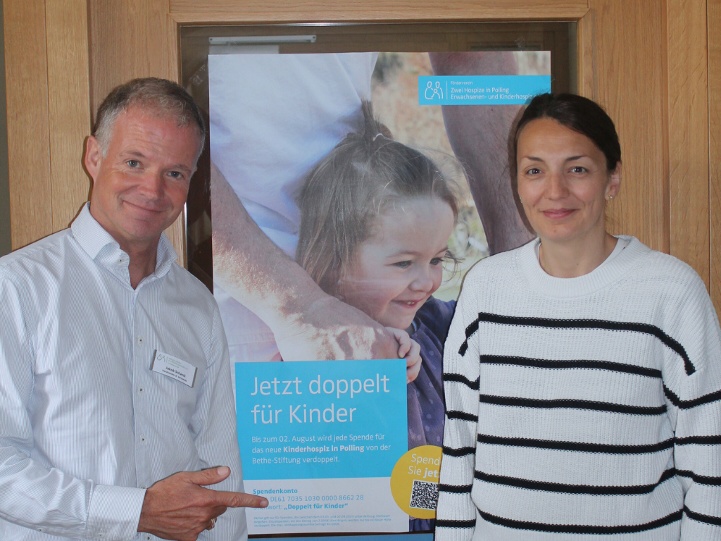 Hospiz Polling - Hospizverein Pfaffenwinkel Plakat zu Spendenaktion, zwei Erwachsene davor.