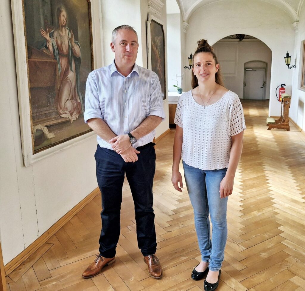 Heller Flur mit Holzboden und Gemälden im Hospiz Polling.