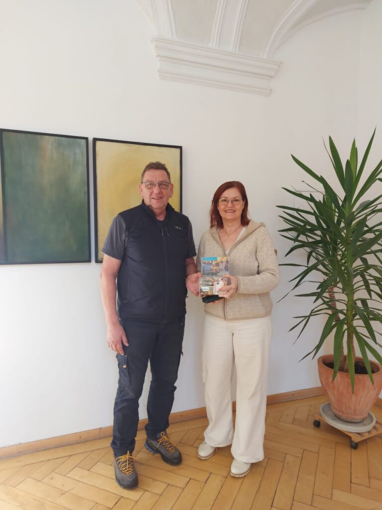 Hospiz Polling - Hospizverein Pfaffenwinkel: Geschenktüten-Übergabe im hellen Raum.