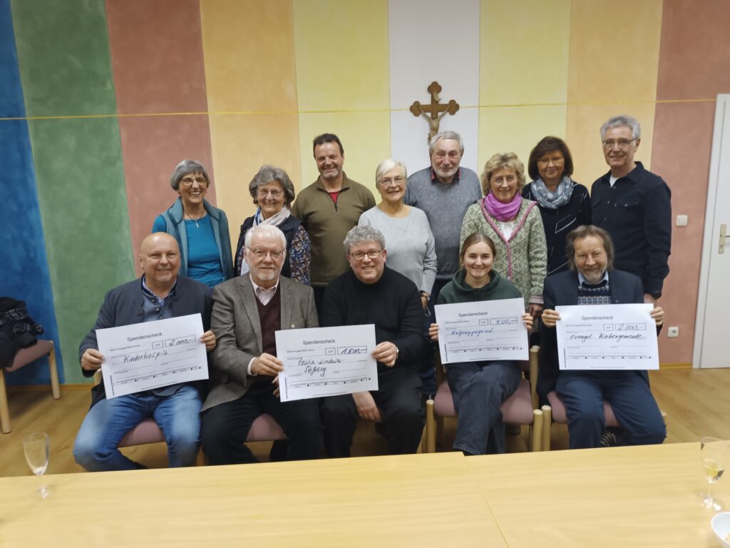 Spendenübergabe im bunten Raum bei Hospiz Polling, fröhliche Stimmung.