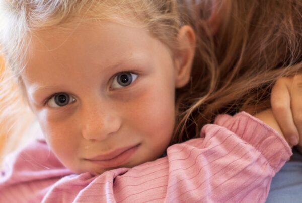 Kinderhospiz St-Martin Mädchen umarmt Frau und schaut in die Kamera