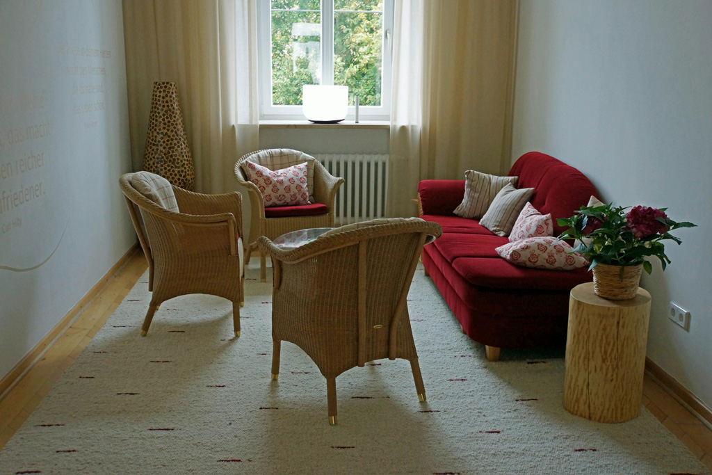 Heller Aufenthaltsraum mit rotem Sofa und natürlichen Details.