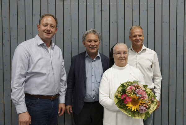 Schwester Raphaela, Oberin des Klosters Polling, mit Blumenstrauß, umgeben von drei Vorstandsmitgliedern des Hospizvereins im Pfaffenwinkel.